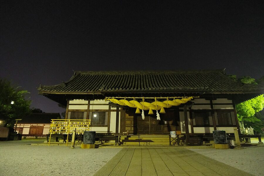 Achi Shrine illuminated at night with red lanterns