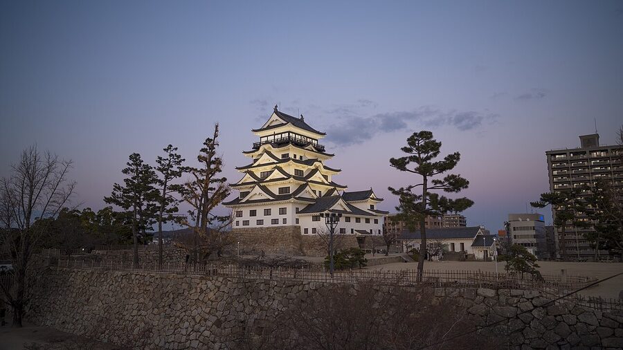 Fukuyama Castle illuminated at sunset with a red-tinged sky