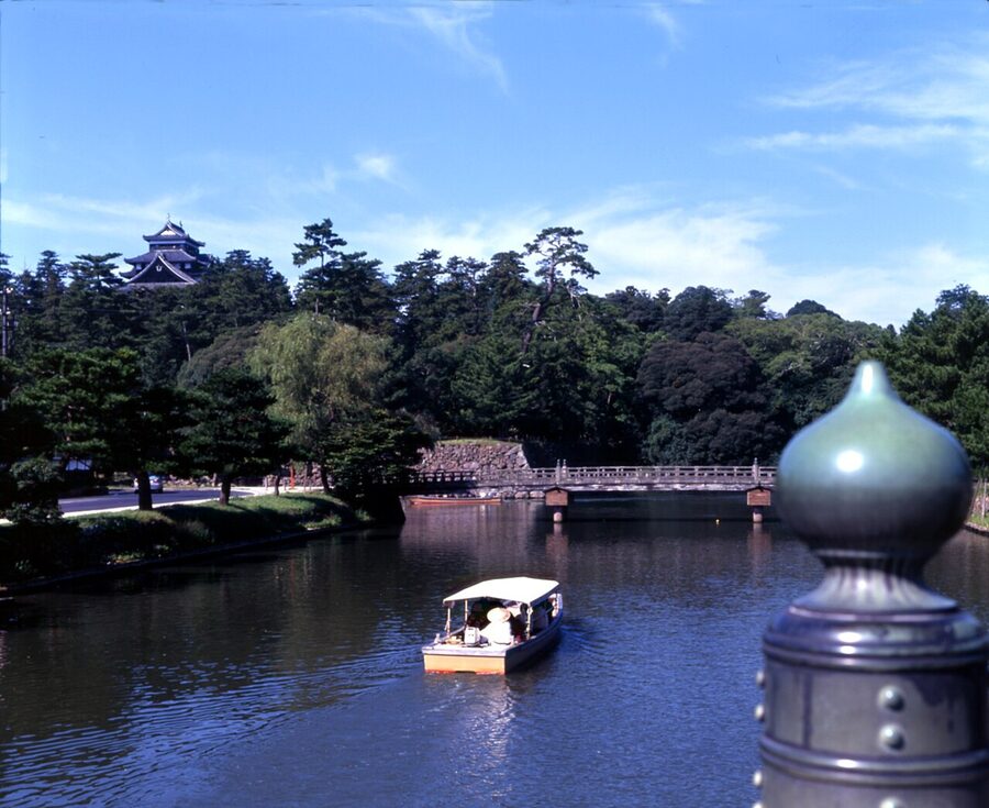 Matsue Horikawa boat passing under a low bridge with a crouched operator