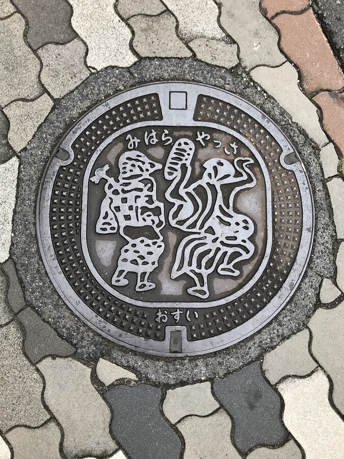 Mihara manhole cover featuring the town's daruma doll mascot and octopus