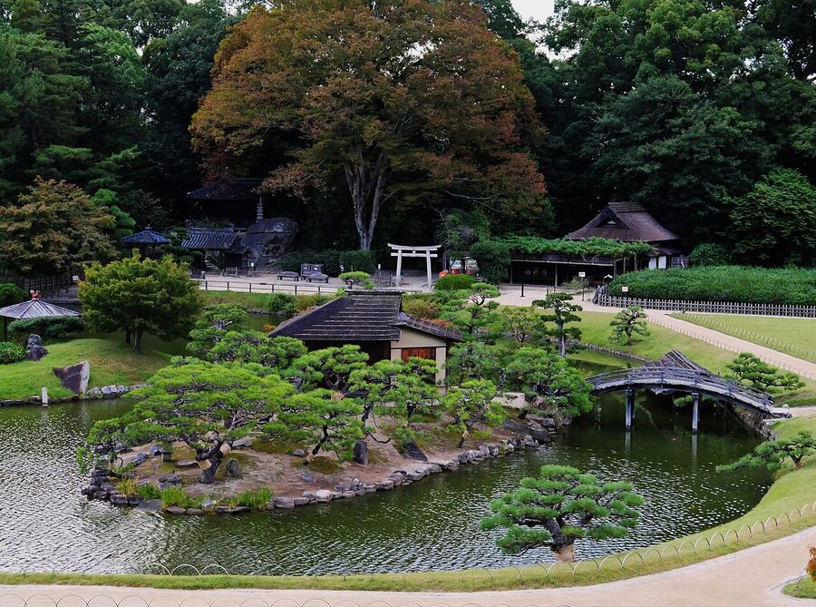 Wide lawn and pond at Okayama Korakuen garden with pavilions in the distance