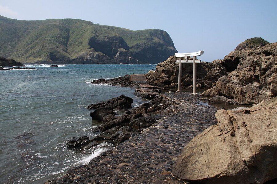 A small red torii gate at the edge of the Kuniga coast cliff
