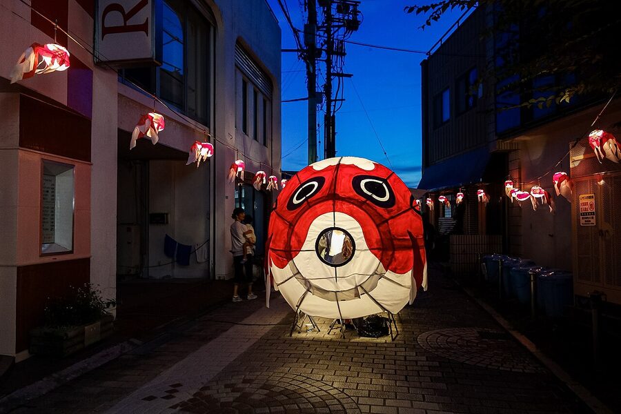 A giant papier-mache goldfish lantern being carried through the streets of Yanai