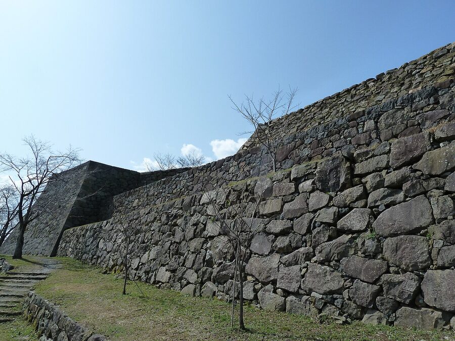 The stone walls of Yonago Castle rising above the surrounding park